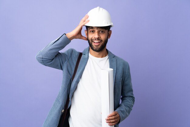 Marokkanischer Mann des jungen Architekten mit Helm und Blaupausen mit Überraschungsausdruck