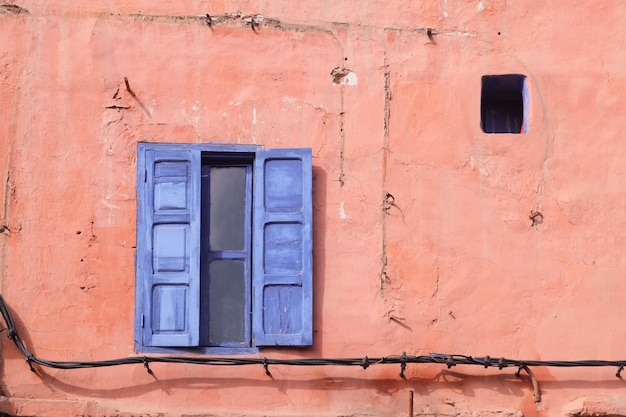 Marrakesch, Marokko. Blaues Fenster auf der rosa Wand.