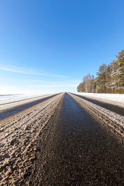 Marrom de neve suja, na estrada no inverno