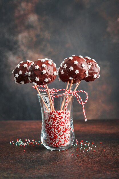 Marry Christmas sweet cake pops Sobremesa de Natal redondo brownie cake pops com estrelas no topo em fundo verde escuro Conceito de sobremesa de comida de Natal e borda de férias em tela larga Vista superior