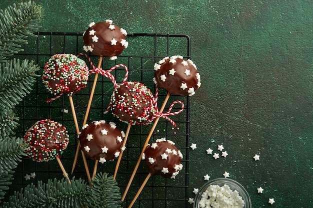 Marry Christmas Sweet Cake Pops Weihnachtsdessert runde Brownie Cake Pops mit Sternen auf dunkelgrünem Hintergrund Weihnachtsessen Dessert Konzept und Szene Breitbild Urlaub Grenze Ansicht von oben