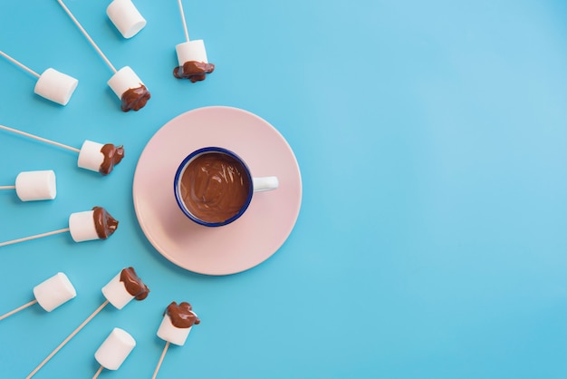 Marshmallow com chocolate em um fundo azul