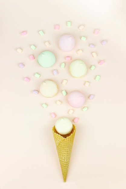 Foto marshmallow doce e brilhante parece macarons na forma de um sorvete em um copo de waffle no meio. conceito de férias e celebração
