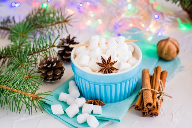 Marshmallow em uma tigela e pau de canela em uma mesa