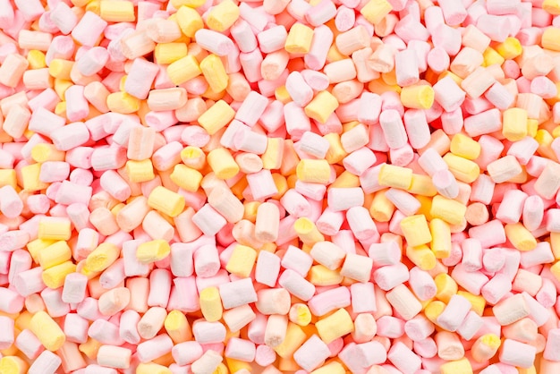 Marshmallow. Fundo de mini marshmallows coloridos rosa e amarelos.