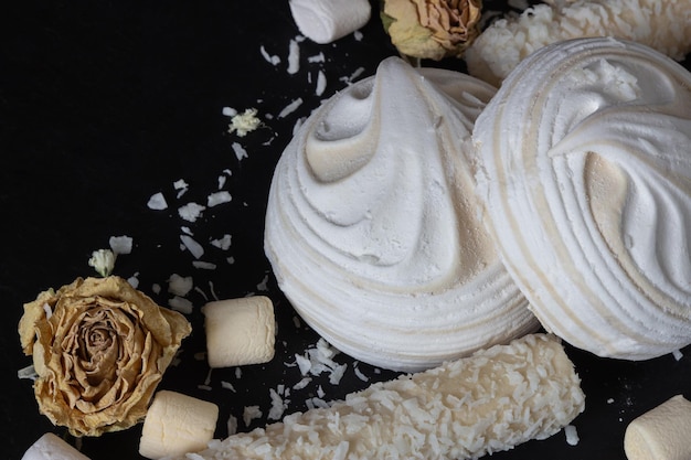 Marshmallows brancos e arejados sobre fundo preto e vista lateral Sobremesa deliciosa
