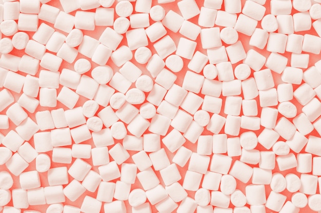 Marshmallows brancos no fundo pastel da cor na moda. lay plana