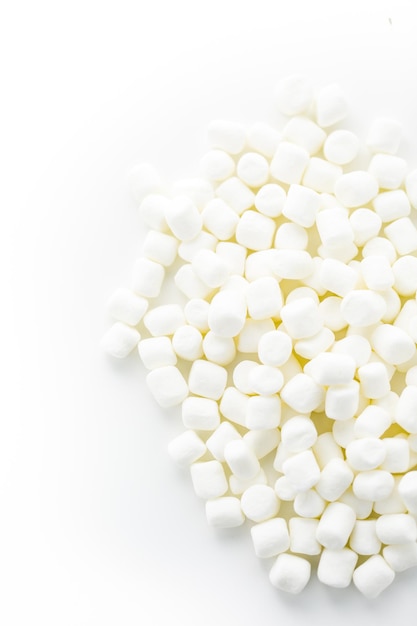 Marshmallows brancos redondos pequenos em fundos brancos.