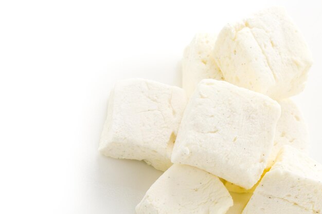 Marshmallows caseiros de feijão de baunilha branca em um fundo branco.