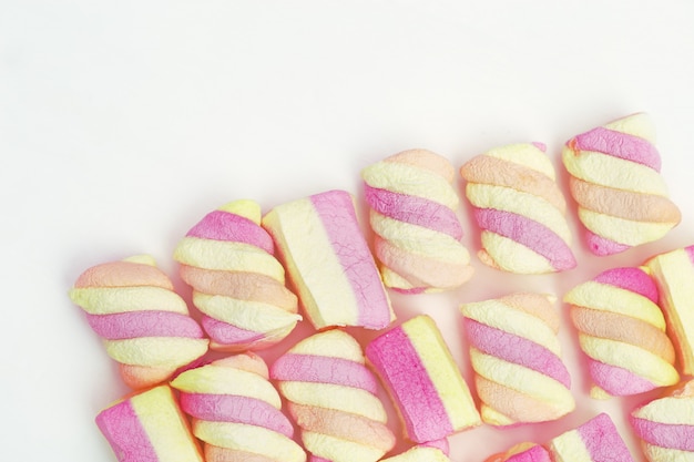 Marshmallows de rosa e amarelos listrados doces em branco