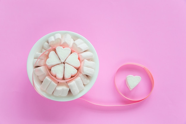 Foto marshmallows em formas de coração para dia dos namorados sobre fundo de papel rosa