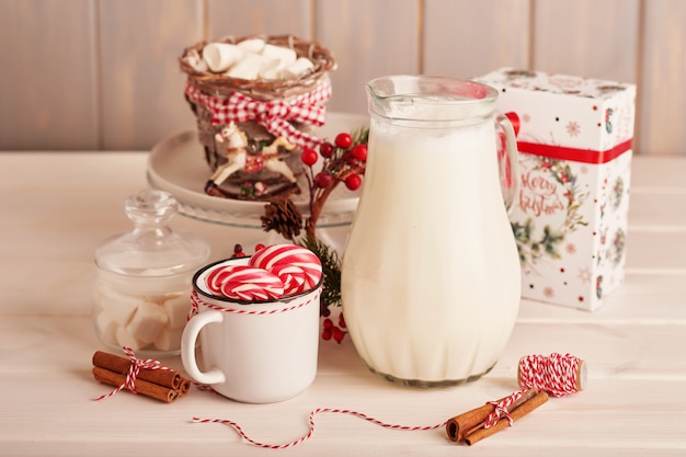 Marshmallows, Lutscher und Milch der Süßigkeiten des neuen Jahres auf dem Tisch mit Geschenken