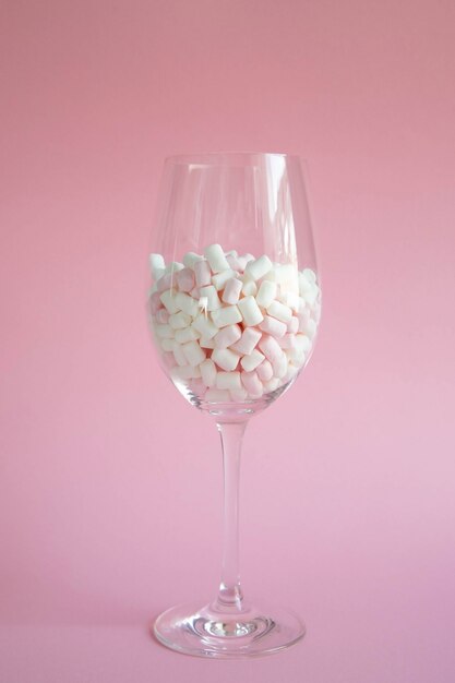 Marshmallows pequenos cor-de-rosa em uma taça de vidro