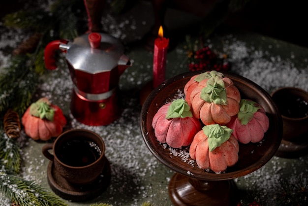 Foto marshmallows rosa caseiros em forma de abóboras cercados por decorações de natal