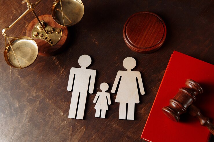 Martelo dos juízes sobre um livro vermelho e figuras familiares