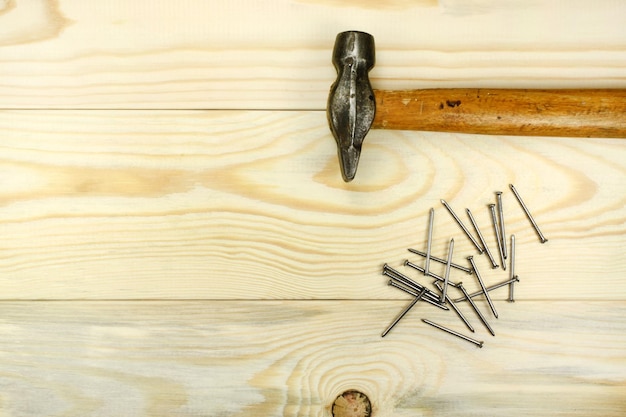 Martillo y clavos en la mesa de madera