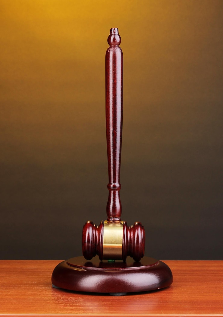 Foto el martillo de los jueces en una mesa de madera sobre un fondo marrón