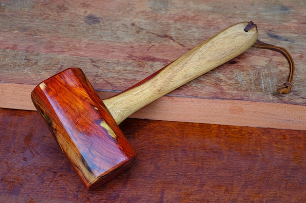 Martillo mazo de madera de palisandro y herramienta hecha a mano de Tailandia para su uso por un carpintero en el taller de la vieja mesa de trabajo