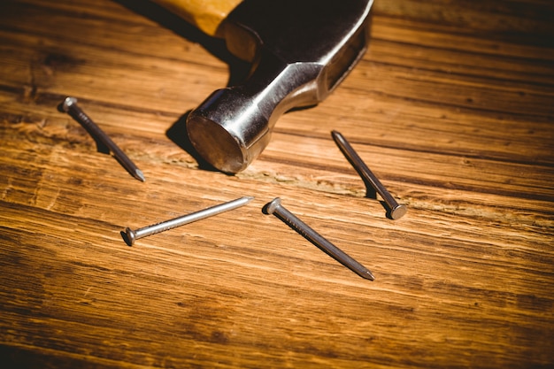 Martillo y uñas dispuestas en la mesa