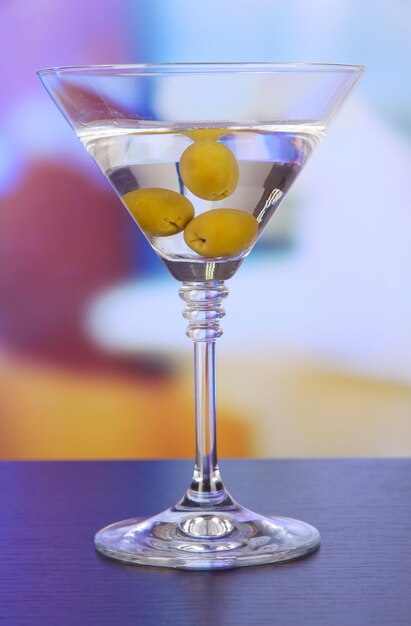 Foto martini con aceitunas verdes en la mesa de bar