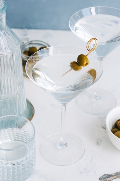 Martini-Cocktail in einem Glas auf weißem Hintergrund mit Oliven