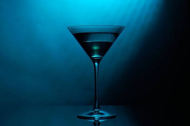Martini-Glas mit blauer Farbe auf Schwarz.