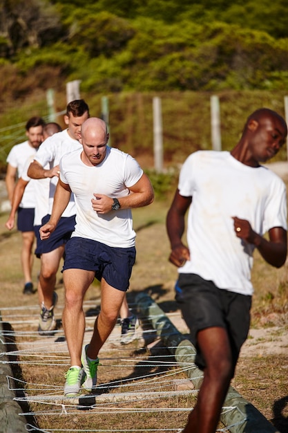 Foto más duro, mejor, más rápido, más fuerte foto de un grupo de hombres haciendo ejercicios en un campamento militar