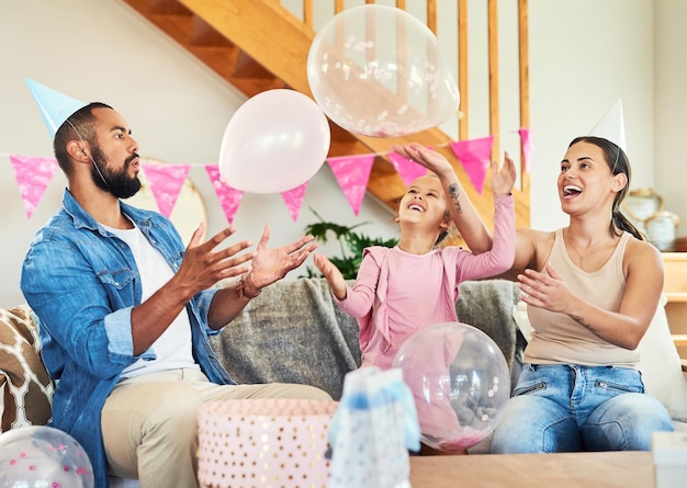 Más globos hacen que sea una verdadera fiesta Foto de una niña celebrando un cumpleaños con sus padres en casa
