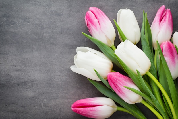 Foto más tulipanes en la mesa gris.