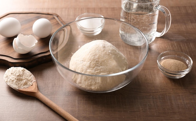 Masa cruda e ingredientes en la mesa de la cocina