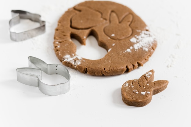 Masa cruda de pan de jengibre de pascua con cortadores y harina