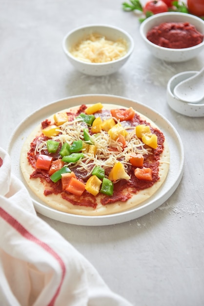 Masa cruda para la preparación de pizza con ingredientes