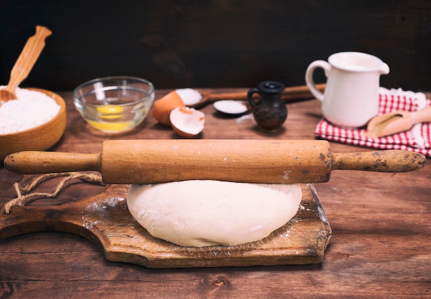 masa de harina blanca y un rodillo de madera