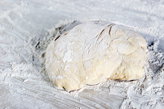 Masa con harina sobre un fondo blanco, masa lista para cocinar