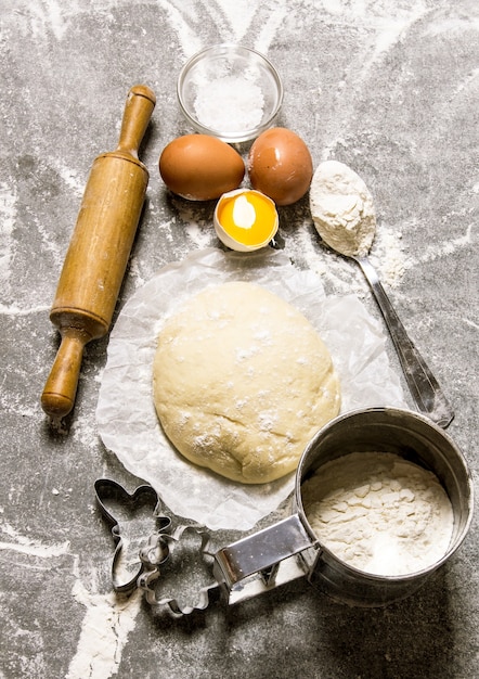 masa y los ingredientes - huevos, harina y herramientas - un rodillo y forma.