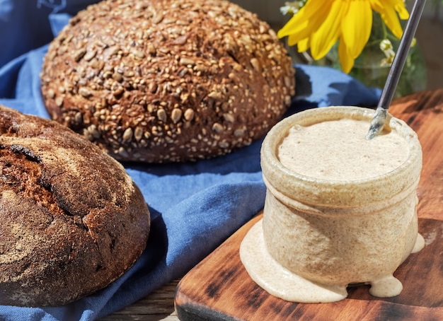 Masa madre para pan en frasco de vidrio y panes caseros