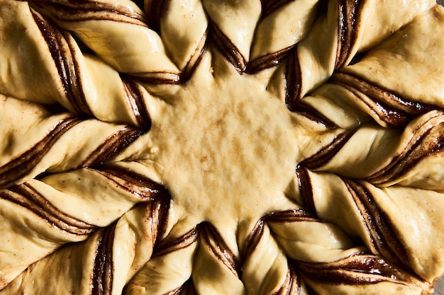 La masa o pastel sin hornear para el pan de estrella de canela en la sábana de hornear sobre un fondo de mármol blanco Vista superior de cerca