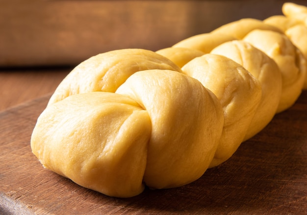 Masa de pan crudo ya en forma de pan sobre madera.