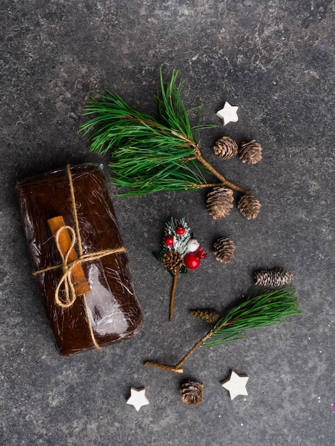 Masa de pan de jengibre de Navidad sobre fondo gris Conos estrellas de madera rama verde bayas rama de canela Tarjeta de Navidad Año Nuevo Imagen elegante atmosférica vacaciones de invierno