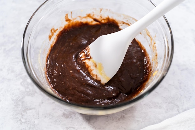 Masa de pastel de chocolate en un tazón de vidrio en el mostrador.