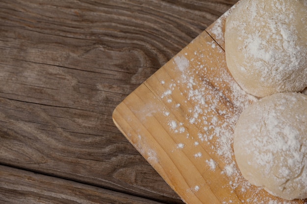 Masa de pizza y harina en la tabla de cortar