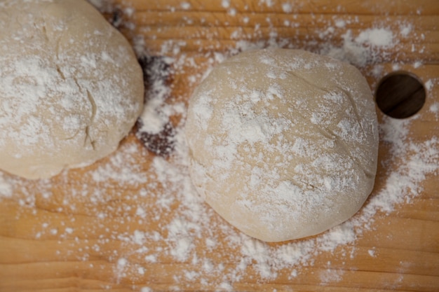 Masa de pizza y harina en la tabla de cortar