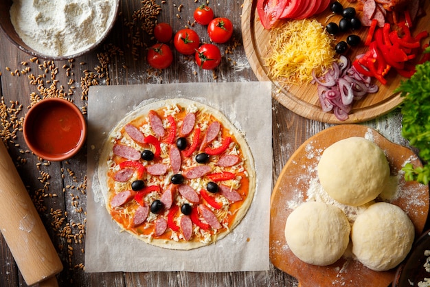 Masa de pizza con ingredientes en madera