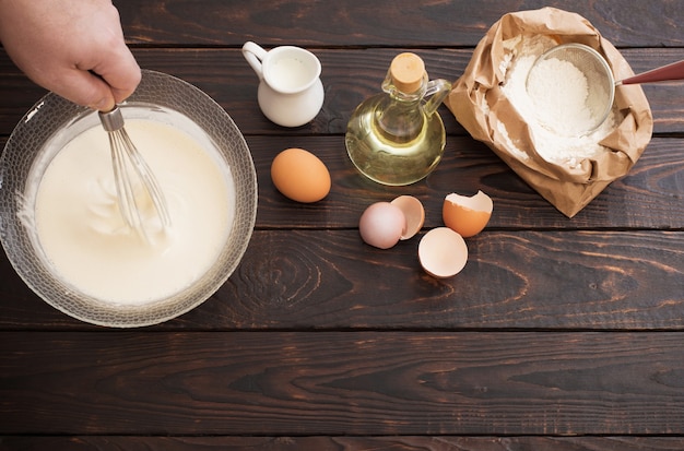 Masa y productos para su preparación sobre fondo de madera oscura.