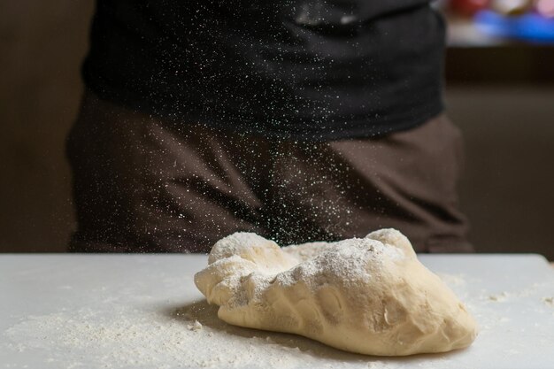 Masa en tabla de cortar sobre la que se vierte harina Preparación de masa de pan para diversos productos