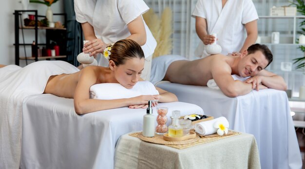 Foto masaje corporal con bolas de hierbas calientes en el spa de día quiescente