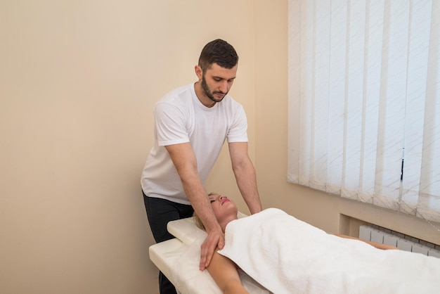 Masaje de cuello y hombros en el salón de spa para un fondo claro de concepto de masaje de bienestar de niña