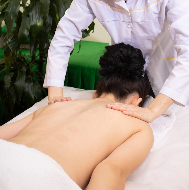 Foto masaje en el cuello en el salón de spa, tratamiento.