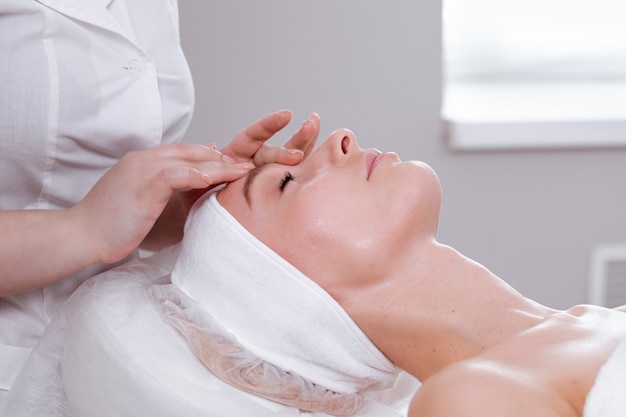 Masaje facial. Concepto de retrato de mujer feliz. Concepto de cuidado de la piel de spa. Tratamiento facial.