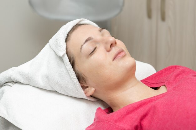 Masaje facial Mujer joven recibiendo tratamiento de masaje spa en el salón de belleza spa Spa cuidado de la piel